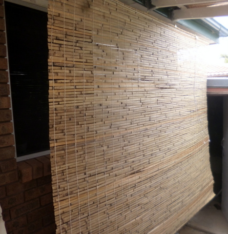 Bamboo blind covering the exposed dining room window and wall